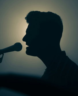 a-silhouette-of-a-man-singing-into-a-microphone.jpg a silhouette of a man singing into a microphone